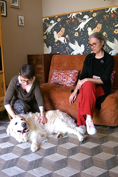 Morgane massant un goden retriever sous le regard attendri de son proporiètaire